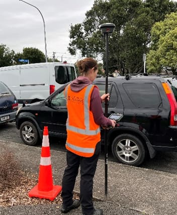 Auckland Land Surveys surveyor taking a GNSS measurement on an Auckland street